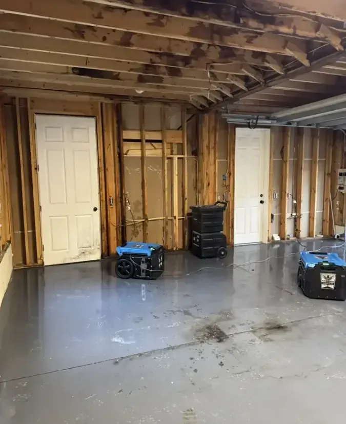 Dehumidifiers drying a gutted lower level during a water damage dry-out