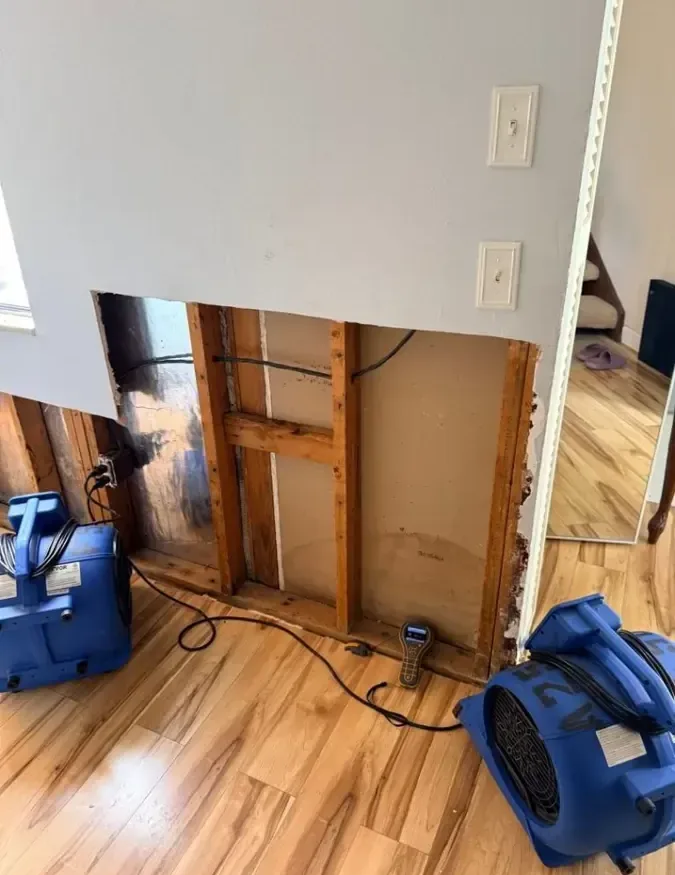 A lower wall cavity opened with air movers aimed at the framing