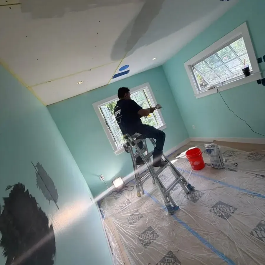 Worker on a ladder over plastic covered floor in a Orinda style dry-out