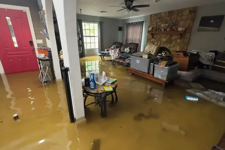 Storm floodwater pooled across a living room floor