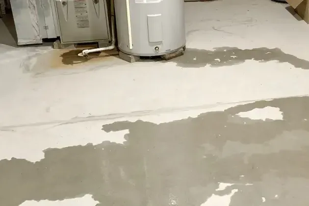 Water running across a garage floor from a failed tank water heater